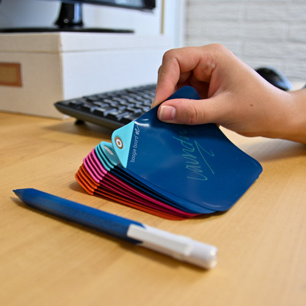 Pile of multiple VersaNotes on a desk with someone grabbing top note