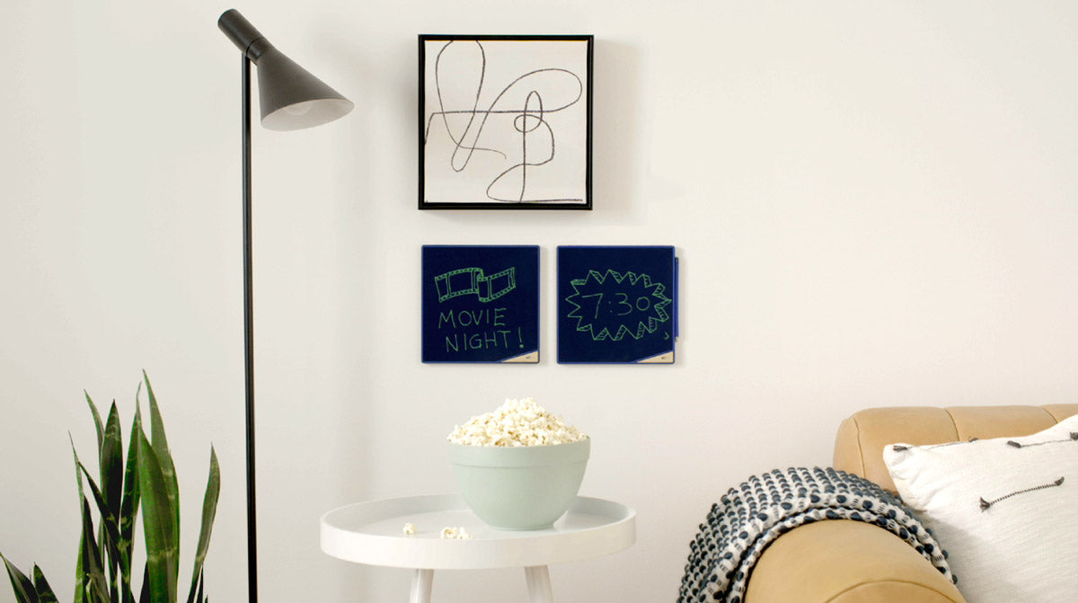 Wall of room with 2 VersaTiles on wall above a small table with bowl of popcorn