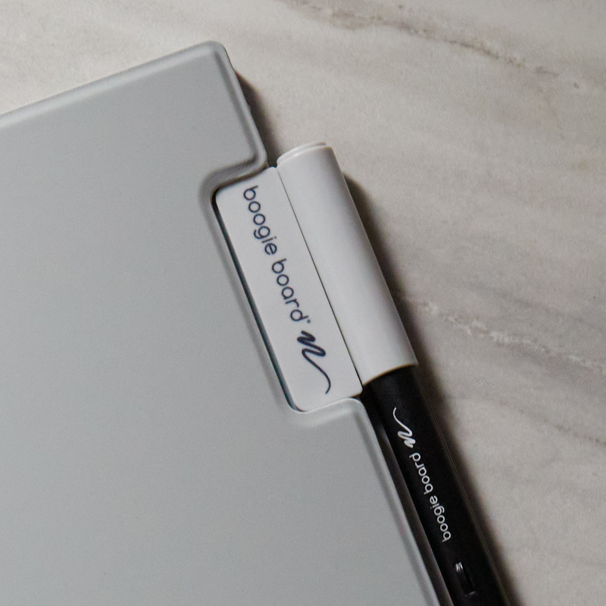 Image of the Smart Pen magnettically attached to the Blackboard 2.0 Reusable notebook