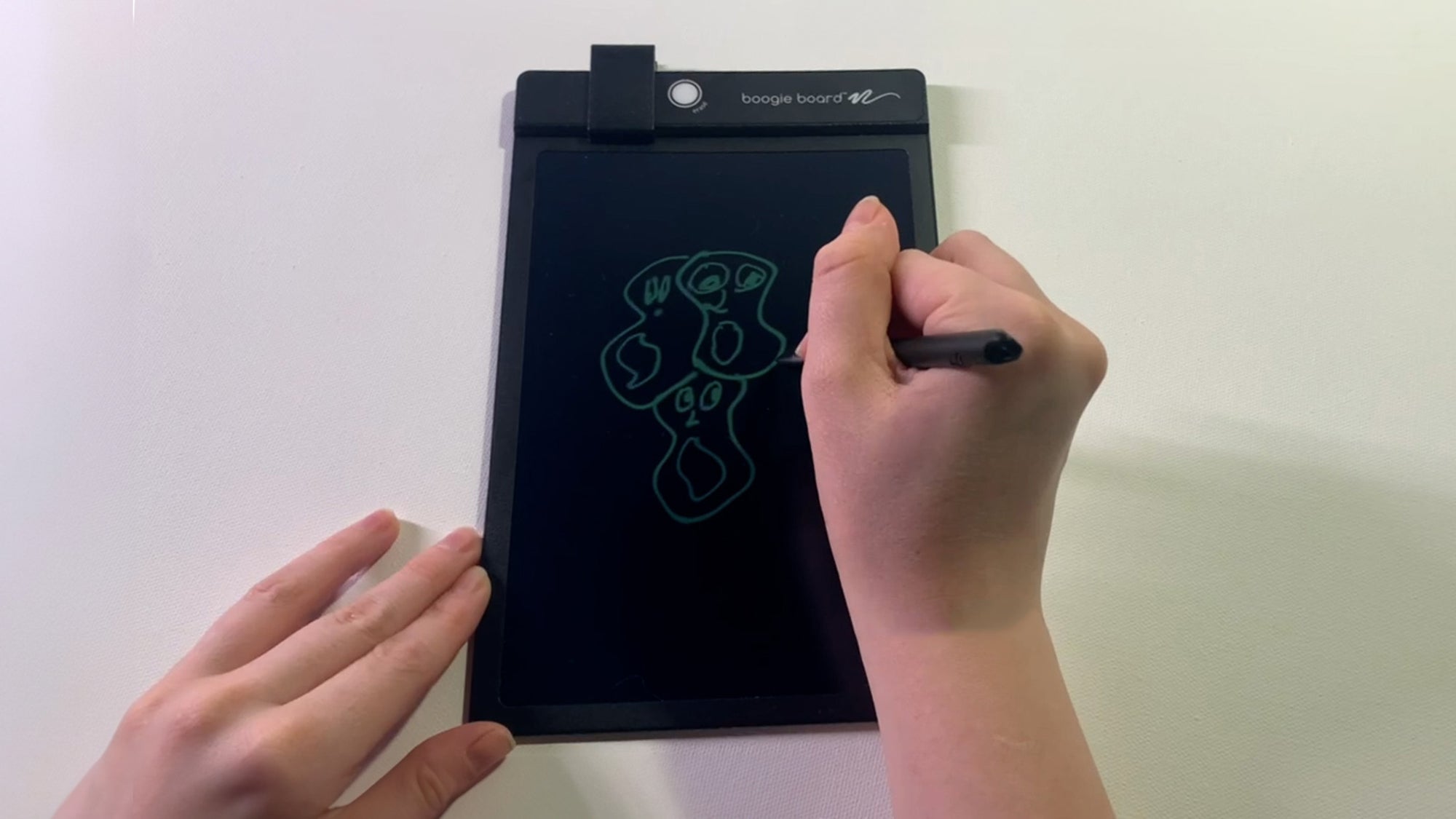 Overhead view of someone writing on a Boogie Board Basics